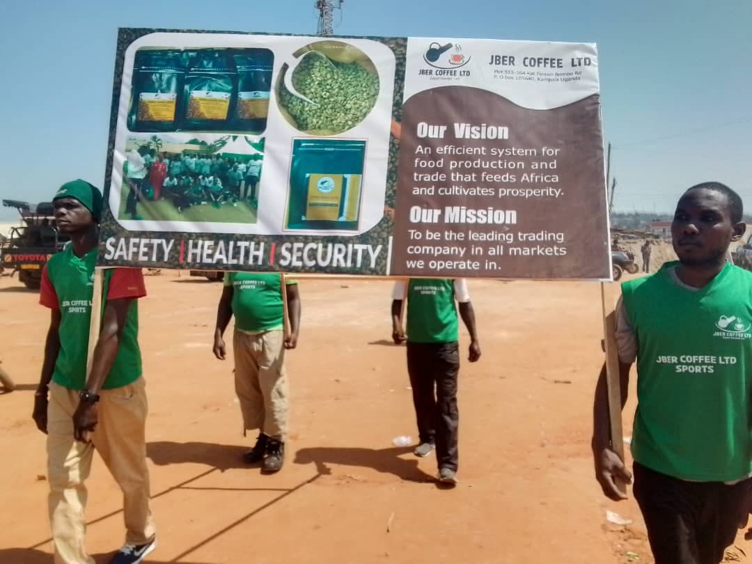 Members of the Jber Coffee team in branded shirts carrying a safety, health and security banner at a community walk.